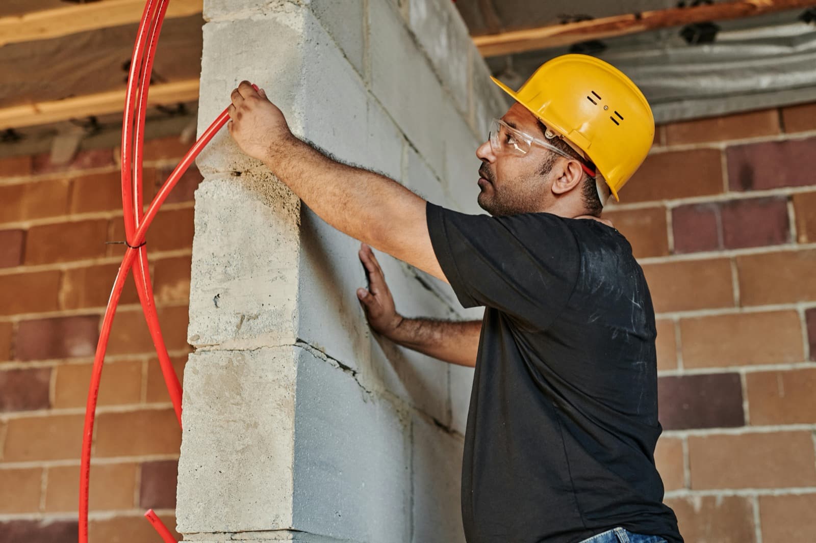 Maçon au travail sur un mur en parpaings